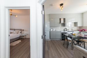 a kitchen and a living room with a dining table at 2 Bed Exceptional Stay in Reading