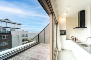 a kitchen with a balcony with a view of the ocean at Apartments in Antwerp South in Antwerp +52 photos