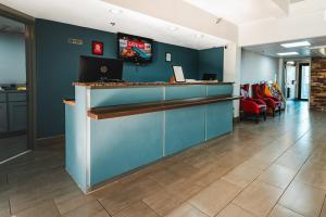 a lobby with a bar with a tv on the wall at HomeTowne Studios by Red Roof San Antonio - SeaWorld Northwest in San Antonio