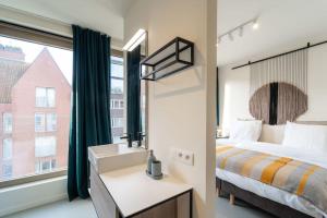 a bedroom with a bed and a sink and a window at Apartments in Antwerp South in Antwerp