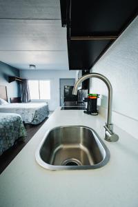 a kitchen with a sink and a bed in a room at HomeTowne Studios by Red Roof San Antonio - SeaWorld Northwest in San Antonio