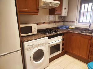 a kitchen with a microwave and a washer and dryer at APCOSTAS Playa Coral - Costa Marfil in Oropesa del Mar