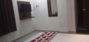 a room with a television and a rug on the floor at Rieva Residency in Kottayam