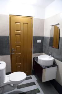a bathroom with a white toilet and a sink at Rieva Residency in Kottayam +8 photos