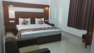 a bedroom with a bed and a couch in a room at Rieva Residency in Kottayam