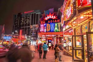 a group of people walking down a city street at night at Niagara Nest - Comfy 1BR and 1BA Close to the Falls in Niagara Falls