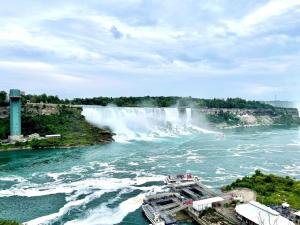 a boat in front of a waterfall on a river at Niagara Nest - Comfy 1BR and 1BA Close to the Falls in Niagara Falls