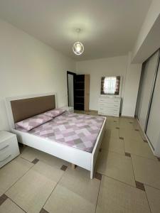 ein Schlafzimmer mit einem großen Bett mit einer rosa Matratze in der Unterkunft Cozy and comfortable apartment in Durrës