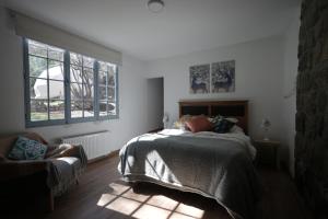 a bedroom with a bed and two windows at Refugio Atreyu in Santiago