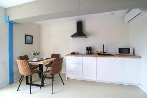a kitchen with white cabinets and a table with chairs at Casa del Pozo in Santillana del Mar