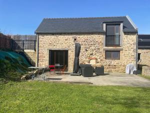 una casa de ladrillo con un patio con muebles delante en Les gîtes d'Izel RDC en Ploemel