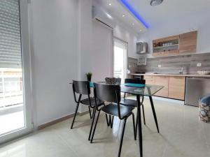 eine Küche mit einem Glastisch und schwarzen Stühlen in der Unterkunft Niki Breeze cozy apartment in Nea Kallikratia + 3 Fotos