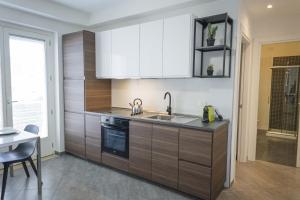 a kitchen with wooden cabinets and a sink and a table at MARIMAR - Apartments OTRANTO in Otranto