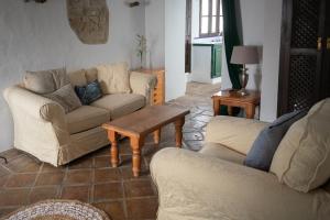 een woonkamer met 2 banken en een salontafel bij Casa Rural Los Sentidos Jimena in Jimena de la Frontera