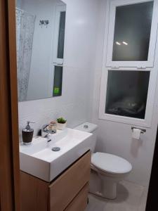 La salle de bains est pourvue d'un lavabo, de toilettes et d'une fenêtre. dans l'établissement Apartamento Cantarero, à Nerja