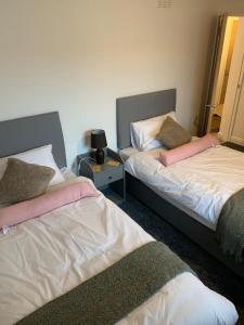 dos camas sentadas una al lado de la otra en una habitación en Dumfries Apartment 2 en Dumfries