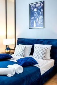 2 Betten in einem Zimmer mit blauem Sofa in der Unterkunft LIKE LAKES Ukiel Park 10 przy plaży i lesie FV in Olsztyn