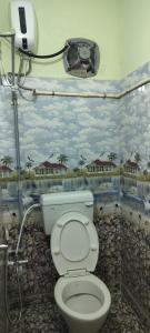 a bathroom with a toilet with a painting on the wall at Vikistays in Chennai