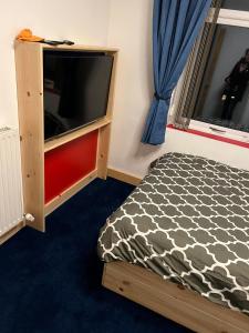 a bedroom with a bed and a flat screen tv at The Comfy House in Huddersfield