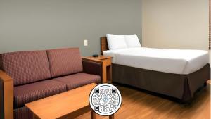 a hotel room with a bed and a couch at WoodSpring Suites Lincoln Northeast I-80 in Lincoln