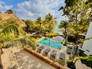 uma vista sobre uma piscina com cadeiras e árvores em Hotel Azulea Bacalar - Lagoon Front em Bacalar