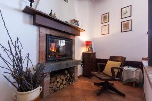 ein Wohnzimmer mit einem Kamin und einem Stuhl in der Unterkunft Ca der Forn the Bread Oven House in Cascina Bricchetto Langhe - Italy in Trezzo Tinella