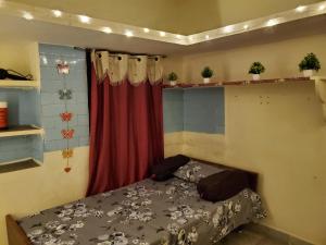 a bedroom with a bed and a red curtain at Entire 2bhk ground-floor suite in independent house in Secunderabad
