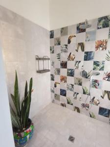 a bathroom with a potted plant and a tile wall at Hotel Amigo Nicaragua in Nindirí