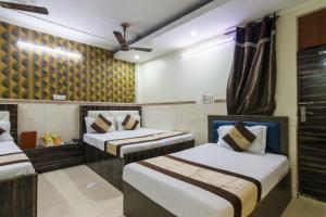 a hotel room with two beds and a ceiling at Hotel Preet - Family Hotel in New Delhi