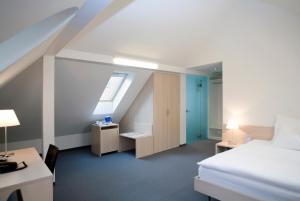 a hotel room with a bed and a desk and a window at Hotel Ochsen in Uster