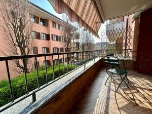 einen Balkon mit einem Tisch und Stühlen sowie ein Gebäude in der Unterkunft Kibilù - Ospedale Galeazzi - Rho Fiera - Milano in Arese