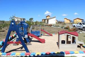 einen Spielplatz mit Spielgeräten im Sand in der Unterkunft Chalés Villa Rica in Carrancas