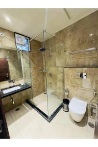 a bathroom with a glass shower with a toilet and a sink at Hotel Jaipur Dreams in Jaipur