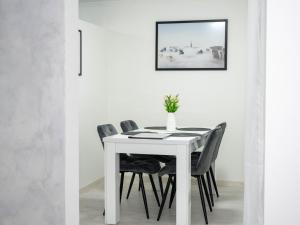 a white dining room table with black chairs at Apartman PLATINUM in Doboj