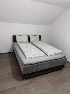Bett in einem Zimmer mit zwei Kissen darauf in der Unterkunft Villa ADA in Jajce
