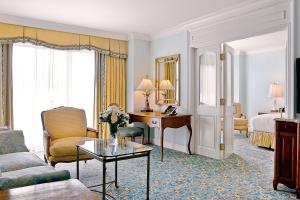 une chambre d'hôtel avec un lit et un salon dans l'établissement Grand America Hotel, à Salt Lake City