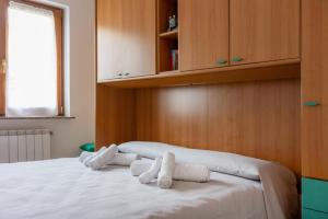 a bedroom with a bed with rolled towels on it at Mara House, Fino del Monte Ospitar in Fino del Monte