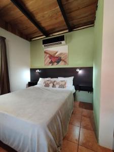 Un dormitorio con una gran cama blanca en una habitación. en Chill-Inn Nosara, en Nosara
