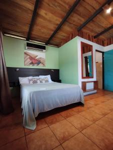 ein Schlafzimmer mit einem großen Bett in einem Zimmer in der Unterkunft Chill-Inn Nosara in Nosara