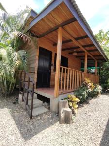 Cabaña pequeña con porche y puerta negra en Chill-Inn Nosara, en Nosara