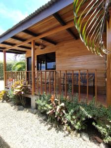 Cabaña de madera con porche y algunas plantas en Chill-Inn Nosara, en Nosara