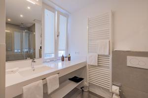 a white bathroom with a sink and a mirror at ATLANTIC Grand Hotel Travemünde in Travemünde