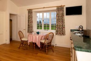 a dining room with a table and chairs and a window at The Retreat at Phillips House in Much Marcle