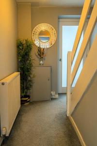 a hallway with a staircase with a chandelier at Modern 3 Bedroom home. A perfect base for Golfers in Ladybank