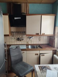 a kitchen with a sink and a chair in it at Red Dot Apartments in Kamen