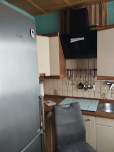 a kitchen with a refrigerator and a sink at Red Dot Apartments in Kamen