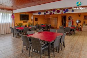 a dining room with red tables and chairs at Complejo Deportivo y Hotelero Flor del Llano in San Clemente