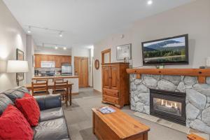 a living room with a fireplace with a tv above it at Lost Lake Lodge by Whistler Premier in Whistler