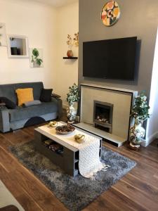 a living room with a couch and a fireplace at Comfort Home From Home Bolton Central Hilden St - Sleeps - 10 in Bolton