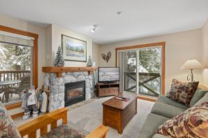 sala de estar con chimenea y TV en Lost Lake Lodge, en Whistler
